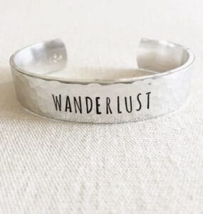 Clair Ashley aluminum cuff bracelet stamped with the word "wanderlust".