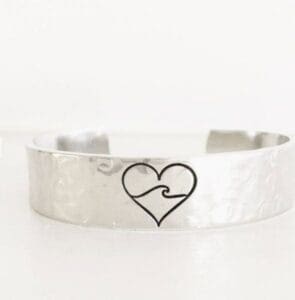 Clair Ashley aluminum cuff bracelet with a hand-stamped heart containing a single wave of water.