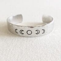 Clair Ashley aluminum cuff bracelet hand-stamped with the phases of the moon. From left, beginning with the new moon, with the full moon centered.