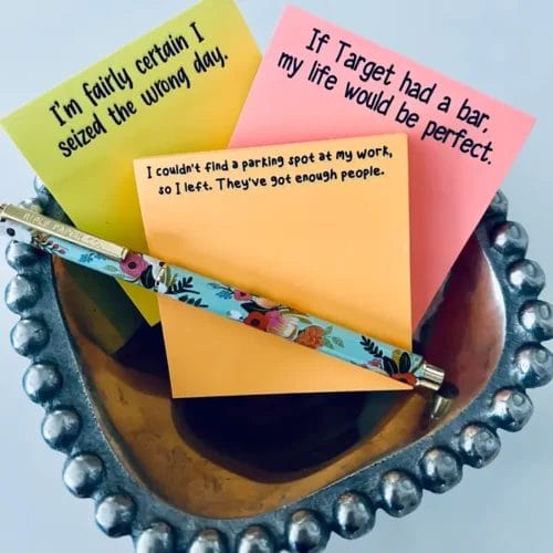 Funny sticky notes and pen in bowl.